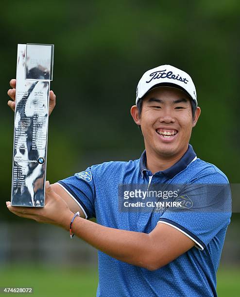 Korean golfer Byeong-hun An celebrates with the trophy after winning the PGA Championship at Wentworth Golf Club in Surrey, south west of London on...