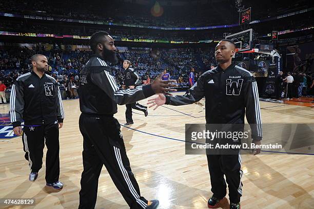 Damian Lillard high fives teammate James Harden of the Western Conference before the game against the Eastern Conference during the 2014 NBA All-Star...