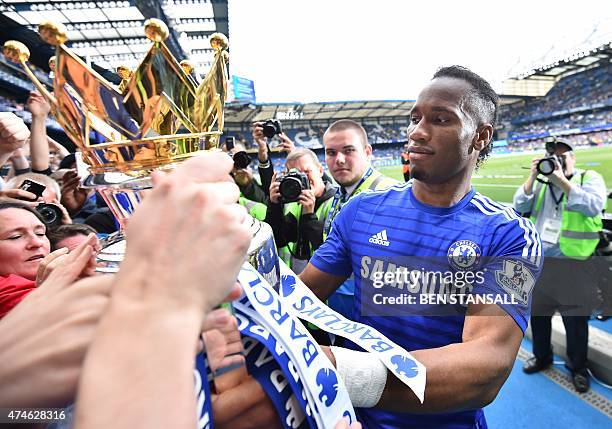 Chelsea's Ivorian striker Didier Drogba shows the Premier League trophy to fans after the presentation following the English Premier League football...