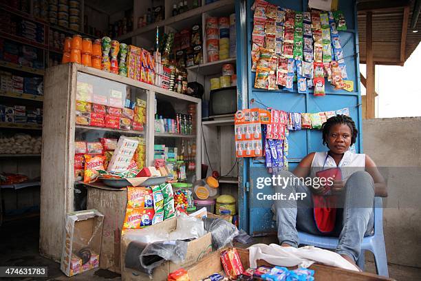 Eva Botchway sits outside her shop in Accra on February 11, 2014. Botchway had to repeatedly raise her prices due to the weakening Cedi . Ghana's...