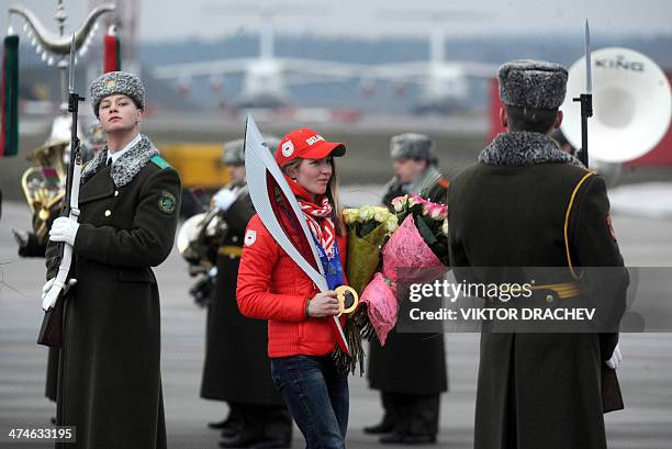 Belarus star biathlete Darya Domracheva walks past honour guard during an official welcome ceremony to mark her arrival from Sochi Winter Olympics in...