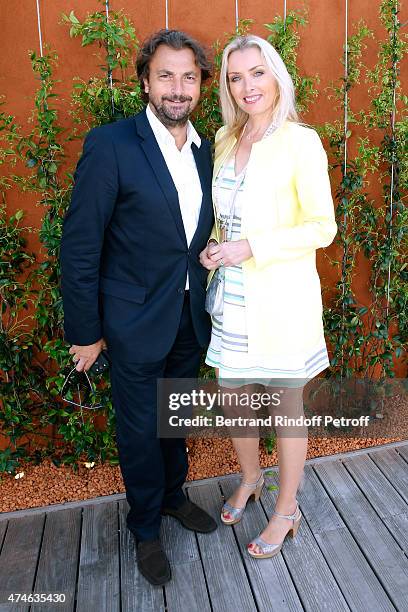 Henri Leconte and a Village hostess attend the 2015 Roland Garros French Tennis Open at Roland Garros on May 24, 2015 in Paris, France.