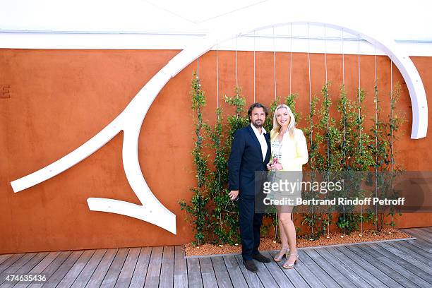 Henri Leconte and a Village hostess attend the 2015 Roland Garros French Tennis Open at Roland Garros on May 24, 2015 in Paris, France.