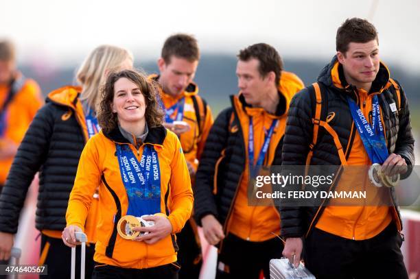 Dutch skaters Ireen Wust and and Sven Kramer hold their medals moments after leaving the plane carrying the Dutch Olympic team, after landing in...