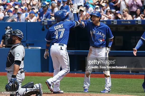 Ryan Goins of the Toronto Blue Jays is congratulated by Munenori Kawasaki after hitting a two-run home run in the fifth inning during MLB game action...