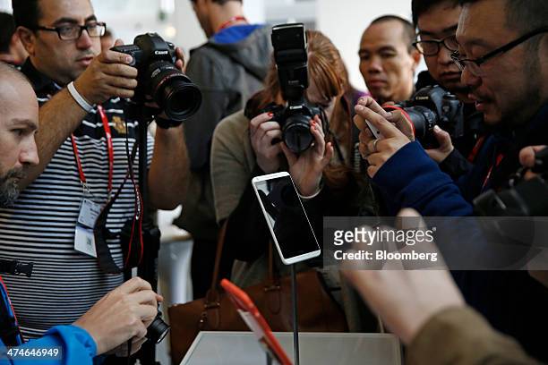 Media crowd around a display to photograph the new HTC Desire 816 smartphone during its unveiling at a news conference on the opening day of the...