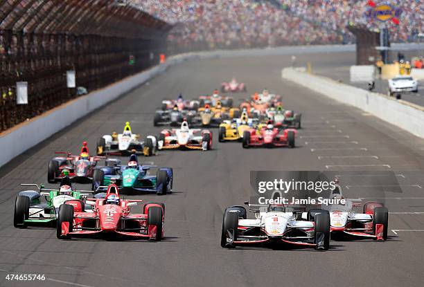 Scott Dixon of Australia, driver of the Target Chip Ganassi Racing Chevrolet Dallara, races alongside Juan Pablo Montoya of Columbia, driver of the...