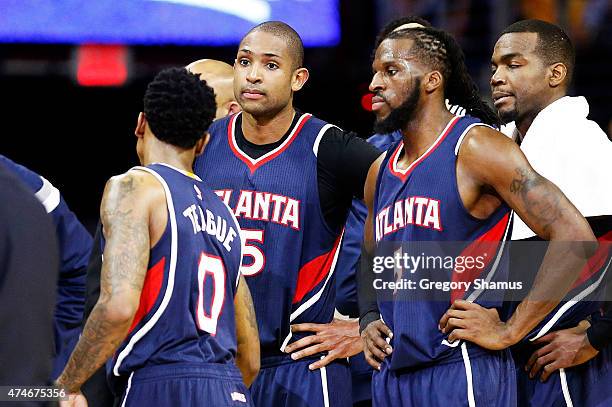 Al Horford talks to DeMarre Carroll and Jeff Teague of the Atlanta Hawks prior to being ejected from the game for a flagrant foul in the second...