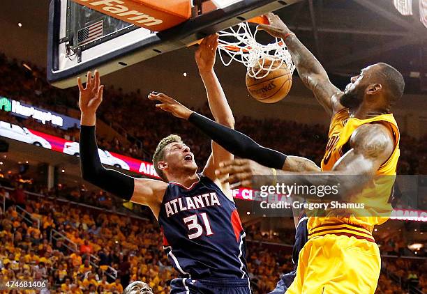 LeBron James of the Cleveland Cavaliers dunks against Mike Muscala and Kent Bazemore of the Atlanta Hawks in the third quarter during Game Three of...