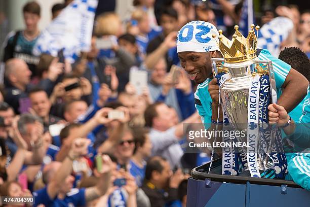 Chelsea's Ivorian striker Didier Drogba holds up the Premier league trophy to fans as the Chelsea team take part in an open-top bus parade through...