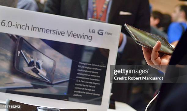 Congress attendee examines the latest LG mobile 'G Flex' at the LG pavilion during Mobile World Congress 2014 on February 24, 2014 in Barcelona,...