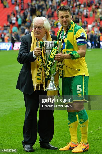 Norwich City's Scottish defender Russell Martin poses with celebrates with Norwich City's joint majority shareholder Michael Wynn Jones after the...