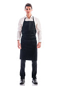 Full length shot of young chef or waiter posing isolated