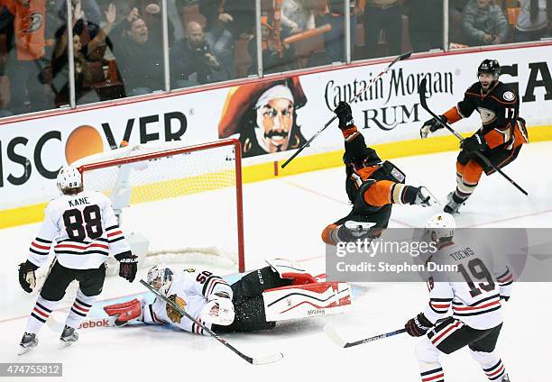 Matt Beleskey of the Anaheim Ducks celebrates scoring the game winning overtime goal as he trips over goaltender Corey Crawford of the Chicago...