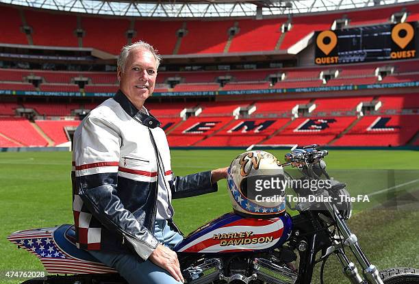 Kelly Knievel poses for photos prior to the Evel Knievel 40th Anniversary at Wembley Stadium with a replica of Evel Knievel's original motor bike and...