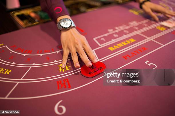 Croupier arranges a player's button on a baccarat table inside the Broadway Macau casino, developed by Galaxy Entertainment Group Ltd., in Macau,...