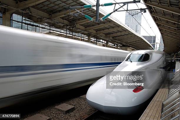 Central Japan Railway Co. N700 series Shinkansen bullet train, right, stands on the platform while another departs from Tokyo Station in Tokyo,...