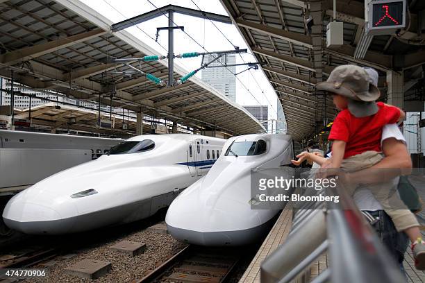 Central Japan Railway Co. N700 series Shinkansen bullet trains stand on the platform at Tokyo Station in Tokyo, Japan, on Sunday, May 24, 2015. Japan...