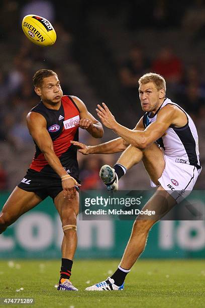 Kane Cornes of the Power kicks the ball away from Leroy Jetta of the Bombers during the round three AFL NAB Challenge match between the Essendon...