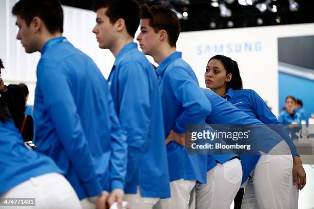 Staff gather for a morning briefing ahead of opening at the Samsung Electronics Co. Pavilion on day two of the Mobile World Congress in Barcelona,...