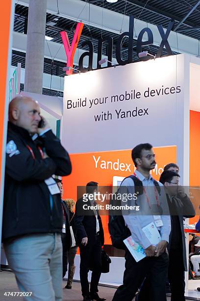 Attendees pass the Yandex NV pavilion on the opening day of the Mobile World Congress in Barcelona, Spain, on Monday, Feb. 24, 2014. Top...