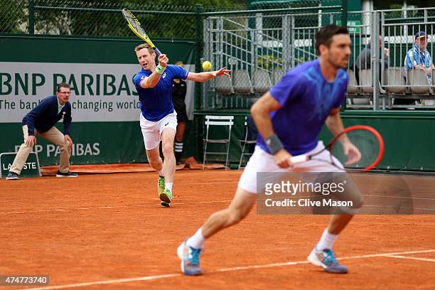 Jonathan Marray of Great Britain returns a shot next to his partner Colin Fleming of Great Britain during their men's doubles match against Feliciano...