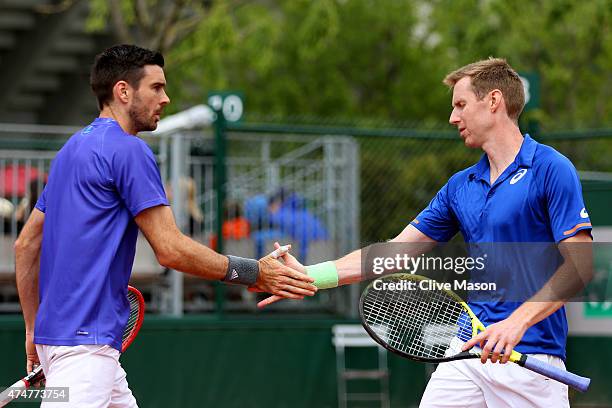 Jonathan Marray of Great Britain taps hands with his partner Colin Fleming of Great Britain during their men's doubles match against Feliciano Lopez...