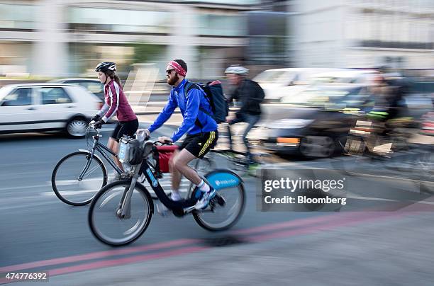 Cyclist rides a London Cycle Hire bicycle, sponsored by Barclays Plc, also known as a "Boris bike", past the junction of Grosvenor Road, and Vauxhall...