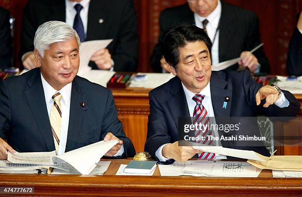 Japanese Prime Minister Shinzo Abe talks with Defense Minister Gen Nakatani on the controversial national security legislation bill during a plenary...