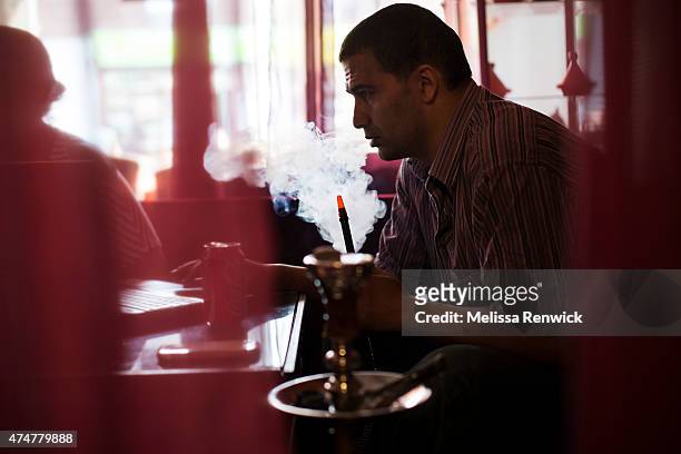 Taoufik Nour smokes from a hookah pipe at The Desert Rose Restaurant and Hookah Lounge, which serves non-tobacco shisha. Hailing from Morocco, Nour...