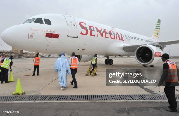 Dakar's airport employee walk next to a Senegal airlines airbus in Dakar, on January 19, 2011. The new airline company, which is equipped with two...