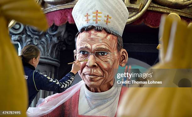 Worker makes final touches to a Carnival parade float satirizing the bishop Franz Peter Tebartz-van Elst under the motto "Living like God in Limburg"...