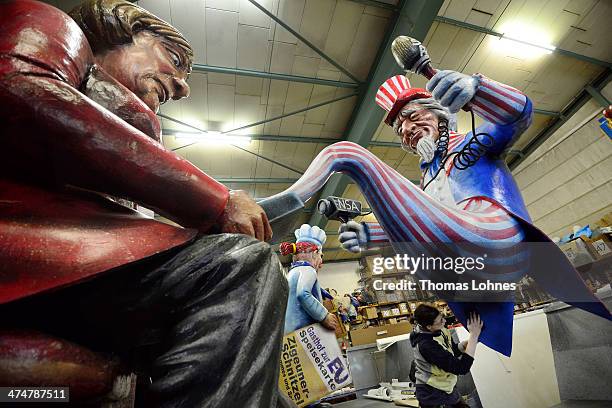 Worker makes final touches to a Carnival parade float satirizing German Chancellor Angela Merkel under the motto "The Spy Who Came in from the phone"...