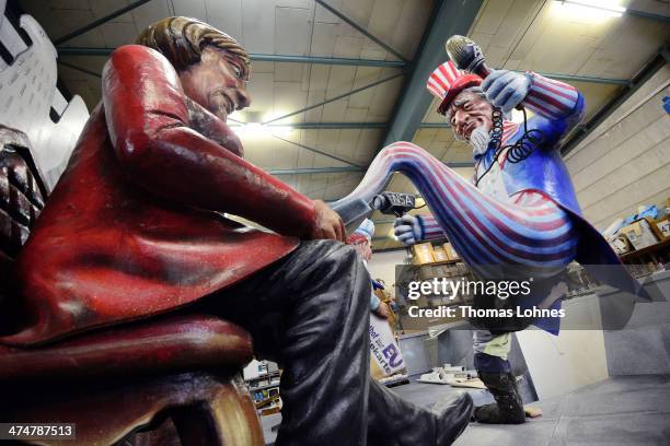 Worker makes final touches to a Carnival parade float satirizing German Chancellor Angela Merkel under the motto "The Spy Who Came in from the phone"...