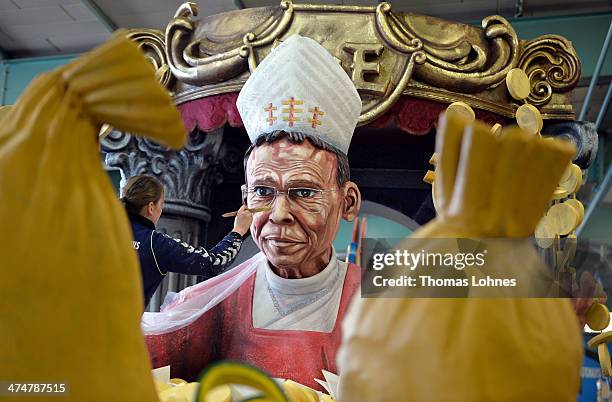 Worker makes final touches to a Carnival parade float satirizing the bishop Franz Peter Tebartz-van Elst under the motto "Living like God in Limburg"...