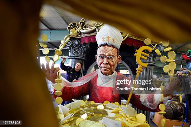 Worker Michelle makes final touches to a Carnival parade float satirizing the bishop Franz Peter Tebartz-van Elst under the motto "Living like God in...