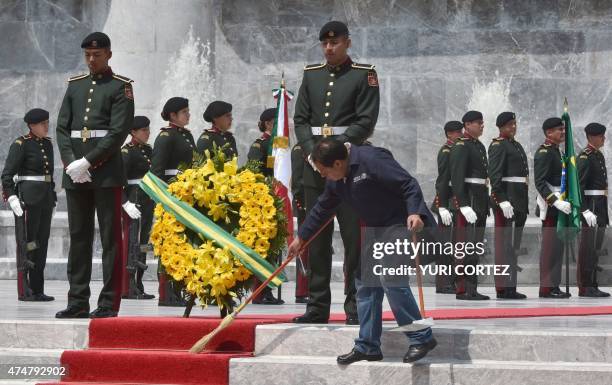 Caretaker sweeps the red carpet before the arrival of Brazilian President Dilma Rousseff to a wreath-laying ceremony at the Ninos Heroes monument in...