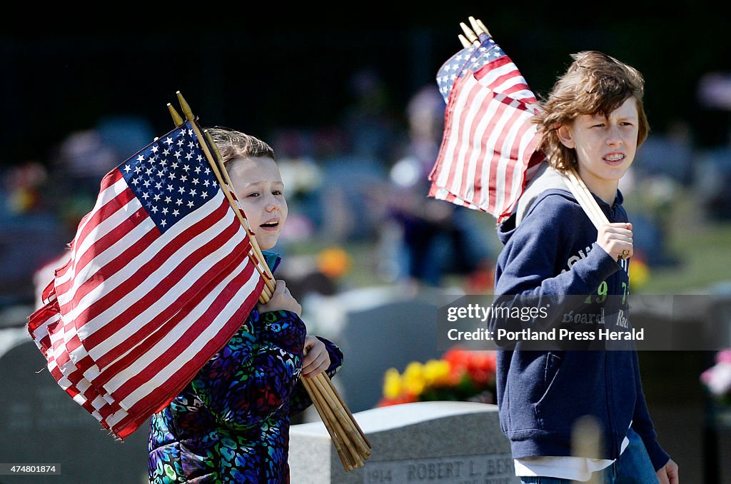 Volunteers place flags on veterans graves