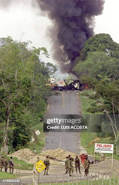 Colombian soldiers look at smoke from the explosion of a car bomb left by Revolutionary Armed Forces of Colombia guerrillas and detonated by the...