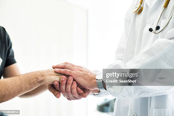doctor holding patient's hands - patient safety stock pictures, royalty-free photos & images