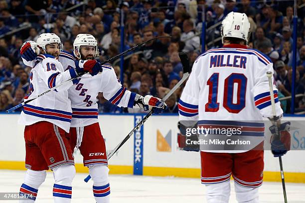 Keith Yandle of the New York Rangers celebrates with teammate Derick Brassard and J.T. Miller after the second goal against Ben Bishop of the Tampa...