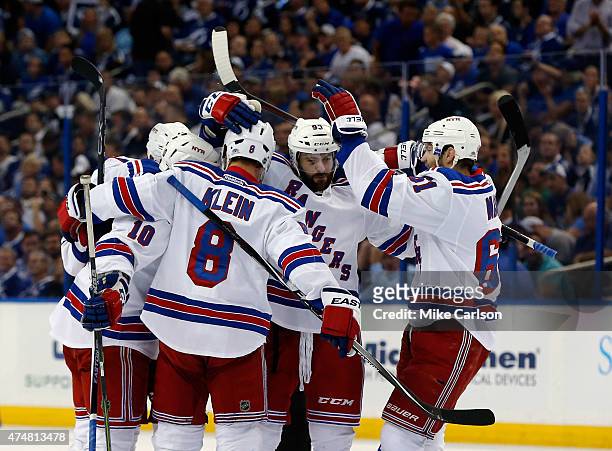 Keith Yandle of the New York Rangers celebrates with teammate Derick Brassard and J.T. Miller after the second goal against Ben Bishop of the Tampa...