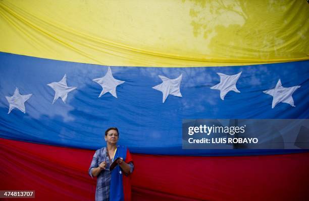 Supporter of Venezuelan opposition leader Leopoldo Lopez, who was arrested a week ago on charges of homicide and inciting violence, hits a pot in...