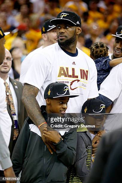 LeBron James of the Cleveland Cavaliers celebrates with his sons LeBron Jr. And Bryce Maximus after defeating the Atlanta Hawks during Game Four of...