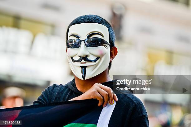 man wearing anonymous mask on a may day, la, usa - guy fawkes mask stock pictures, royalty-free photos & images