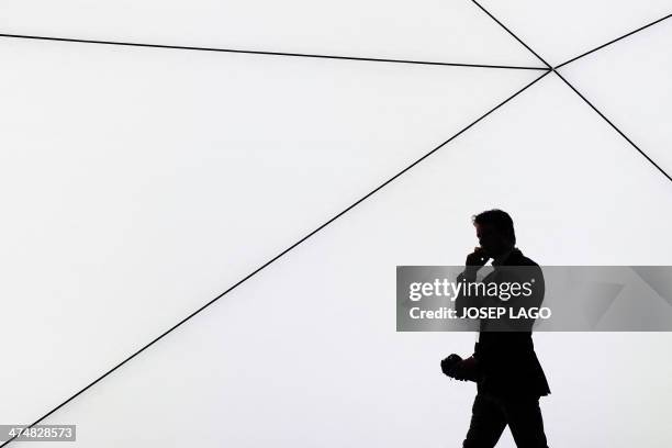 Visitor speaks on his phone in Barcelona on February 25, 2014 during the second day of the 2013 Mobile World Congress. The 2014 Mobile World...