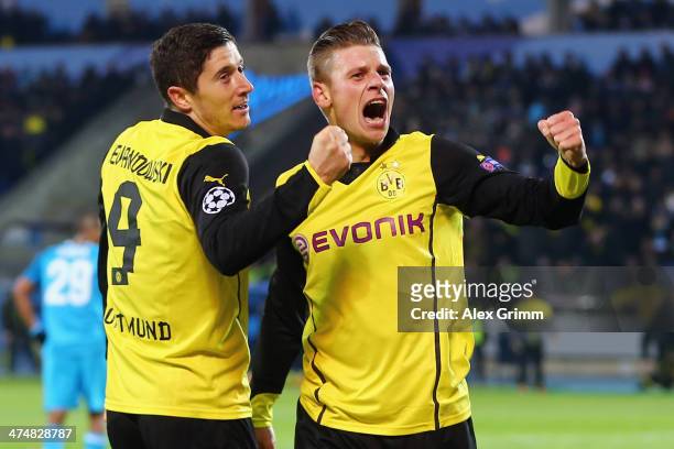 Robert Lewandowski of Dortmund celebrates his team's third goal with team mate Lukas Piszczek during the UEFA Champions League Round of 16 match...