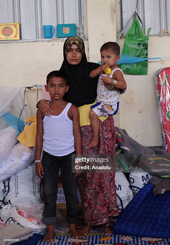 A Rohingya migrant woman looks after two orphans in Aceh