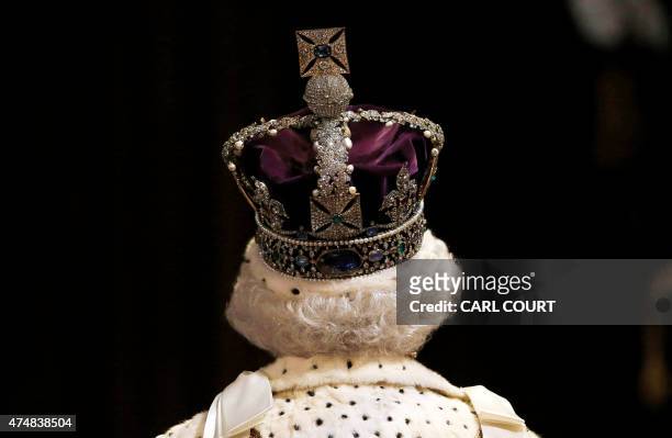 Britain's Queen Elizabeth II, wearing the Imperial State Crown, proceeds through the Royal Gallery as she attends the State Opening of Parliament in...