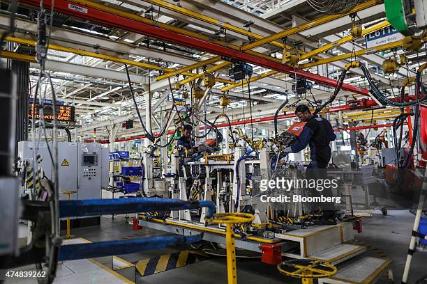 Employees operate vehicle body welding machinery on the BharatBenz truck production line of the Daimler India Commercial Vehicles Pvt. Manufacturing...